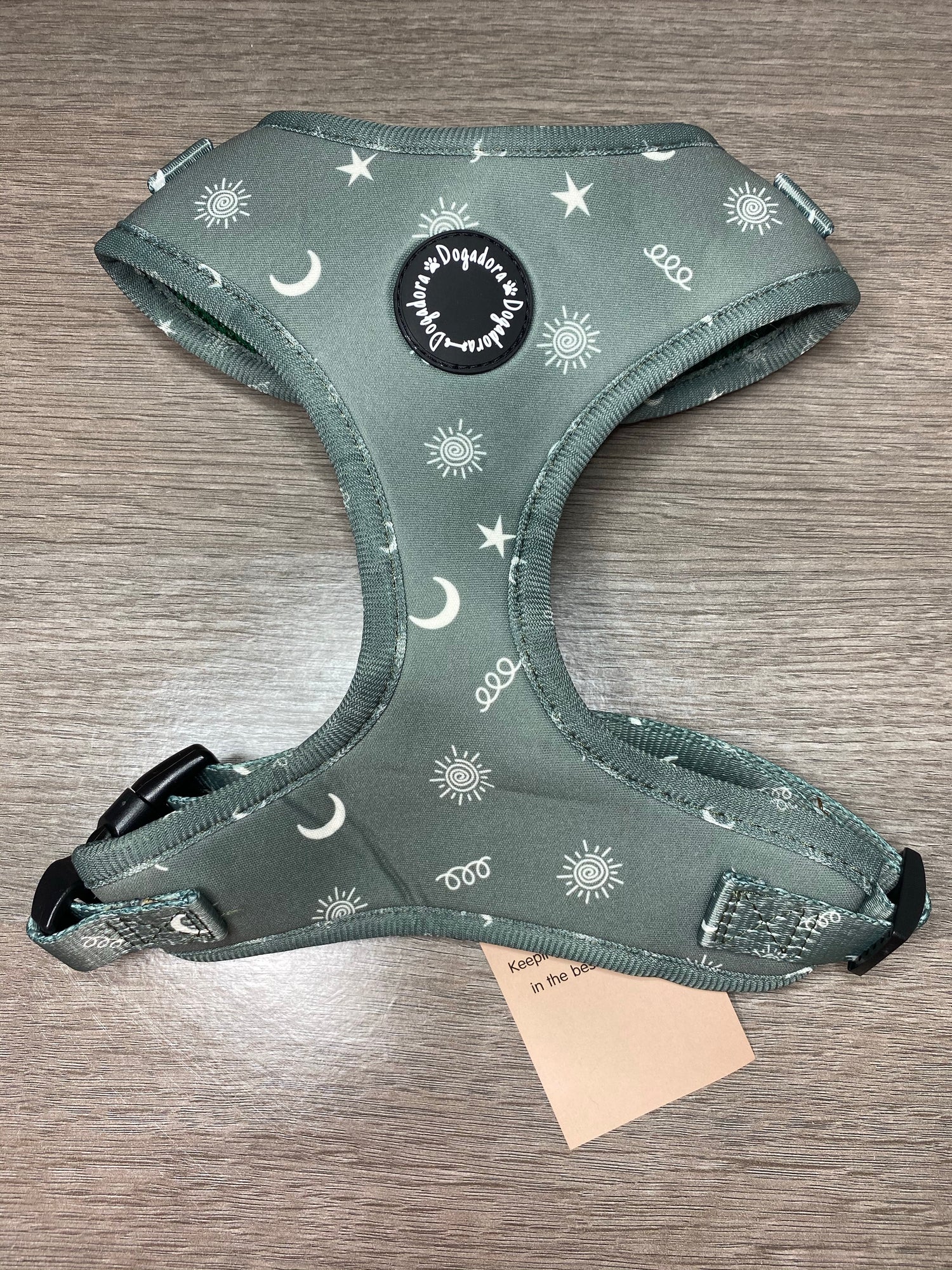 Dogadora fully adjustable dog harness. In a green design with beige stars, moons and suns with a swirly pattern. Soft and padded